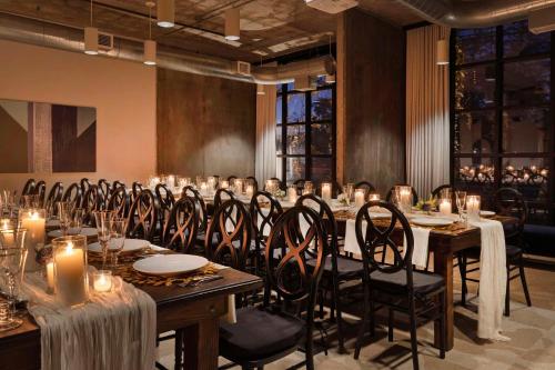 a dining room with a long table with candles at The LOOM Hotel, Tapestry Collection by Hilton in Warwick