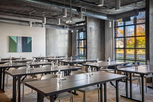 a room with tables and chairs and windows at The LOOM Hotel, Tapestry Collection by Hilton in Warwick