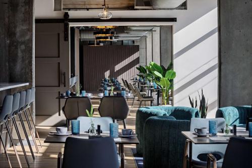 a restaurant with blue chairs and tables in a room at The LOOM Hotel, Tapestry Collection by Hilton in Warwick