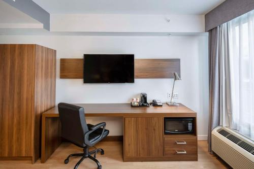 a room with a desk with a television and a chair at Quality Inn in Quebec City