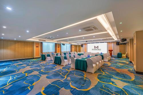 a conference room with chairs and a table and a screen at Meihao Mingyue Hotel International Finance City Keyun Road Metro Branch in Guangzhou