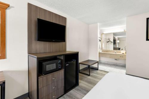 a hotel room with a flat screen tv on a wall at Quality Inn Middleburg Heights near Cleveland Airport in Middleburg Heights