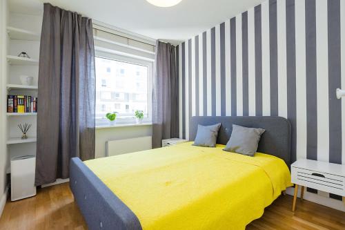 ワルシャワにあるPiękny apartament w Warszawieのベッドルーム1室(黄色いベッド1台、窓付)