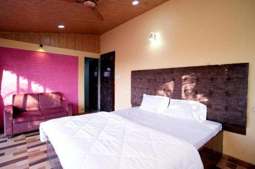 a bedroom with a large white bed and a chair at Malama Stay The Dusk Villa 3BHK Lonavala in Lonavala