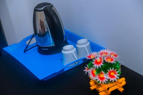 un monitor di computer appoggiato su una scrivania con dei fiori di Mirissa Breeze a Mirissa