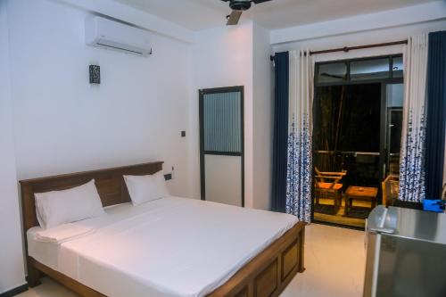 a bedroom with a bed and a view of a patio at Mirissa Breeze in Mirissa