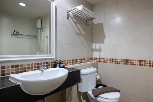 a bathroom with a sink and a toilet and a mirror at Nature Boutique Hotel Ratchayothin in Bangkok