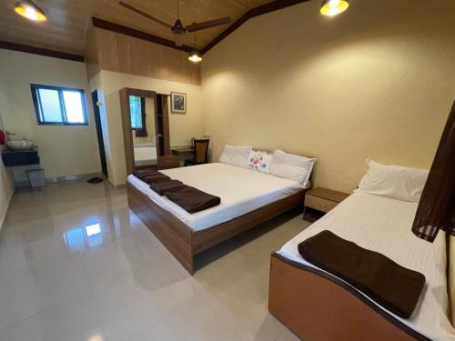 a bedroom with two beds with white sheets at RS Farms in Vasind