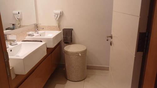 a bathroom with two sinks and a trash can at Cap Ouest Luxury Beachfront in Flic-en-Flac