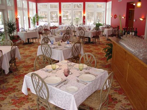 a dining room with white tables and chairs at Garth Woodside Mansion Bed and Breakfast in Hannibal