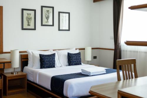 a bedroom with a bed with blue and white pillows at Nature Boutique Hotel Ratchayothin in Bangkok