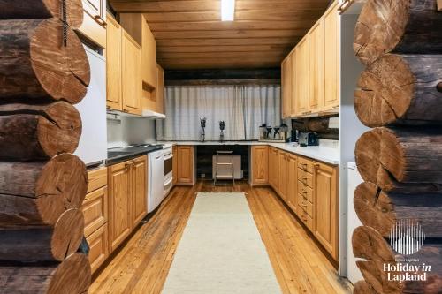 una cucina con armadi in legno e pavimenti in legno di Holiday in Lapland - Ukonlammentie 11 a Kuusamo