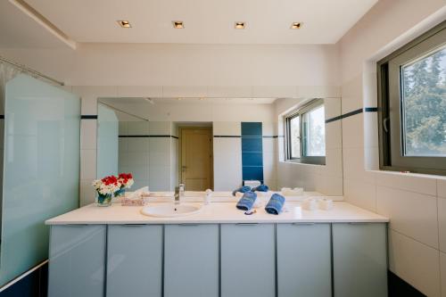 a bathroom with a sink and a mirror at Caza Bella Vista a Luxurious House in Kos Town
