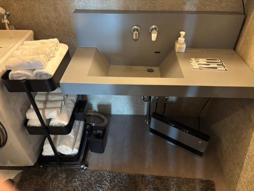 a bathroom with a sink and towels under a counter at B-sum M-1 in Matsuzaka