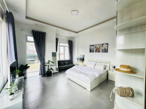 a white bedroom with a bed and a couch at Say Homestay - Venuestay in Da Thien