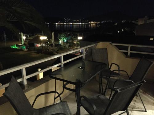 a table and chairs on a balcony at night at Vournelis Beach Hotel and Spa in Iraklitsa