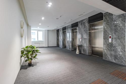 an empty hallway with a potted plant in a building at Y'estoria апарт-отель, район EXPO центра in Astana