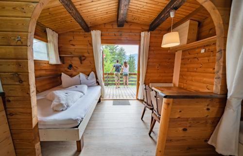 a room in a log cabin with a bed and a desk at Alpenferienpark Reisach in Reisach