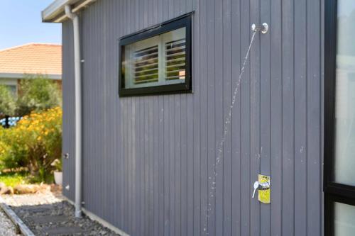 a building with a window on the side of it at Seagrass Studio Guesthouse - By the Beach in Tairua