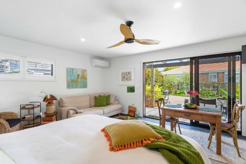 a bedroom with a bed and a living room at Seagrass Studio Guesthouse - By the Beach in Tairua