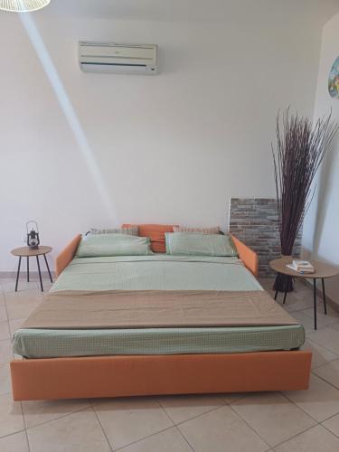 a bed in a room with two tables at Tinnari home in Cascabraga