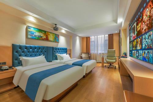 a hotel room with two beds and a tv at Meihao Mingyue Hotel International Finance City Keyun Road Metro Branch in Guangzhou
