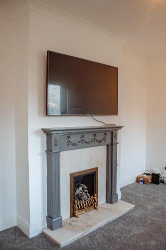 a fireplace with a television on top of it at Spacious 4-Bed Flat - 10 Mins to City Centre in Roundhay