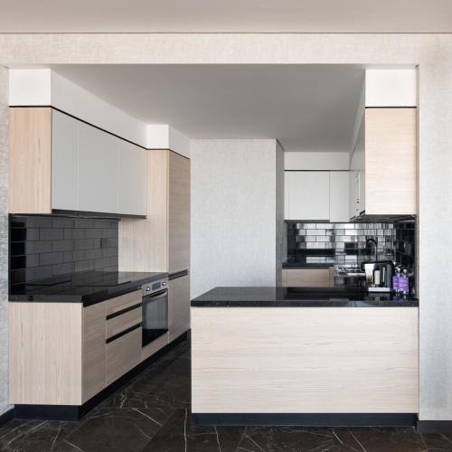 a kitchen with white cabinets and black counter tops at Park Inn by Radisson Hotel & Apartments Kuwait in Kuwait