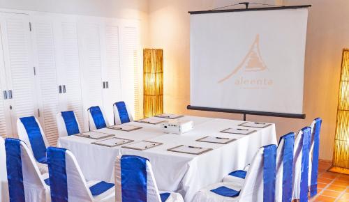 a meeting room with a white table and blue chairs at Aleenta Hua Hin - Pranburi - The Small Luxury Hotels of the World in Pran Buri
