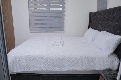 a bed with white sheets and a white object on it at One Bedroom apartment A3 in Cape Town