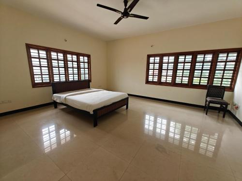 a bedroom with a bed and a ceiling fan at 6bhk Luxury Villa in Mysore