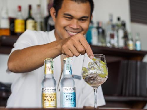a man pouring a drink in a wine glass at Aleenta Hua Hin - Pranburi - The Small Luxury Hotels of the World in Pran Buri