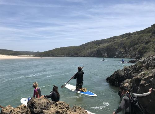 a group of people on surfboards in the water at AumHome Guesthouse in Aljezur