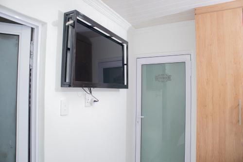 a flat screen tv on a wall next to a door at One Bedroom apartment A3 in Cape Town
