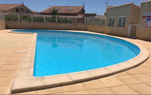 une grande piscine bleue dans une cour dans l'établissement Pavillon 3 pièces - Gruissan Ayguades AY060-056, à Vires