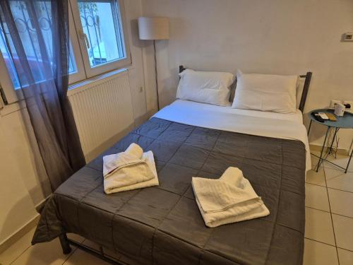 ein Bett in einem Zimmer mit zwei Handtüchern darauf in der Unterkunft City Studio Kavala in Kavala