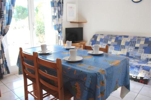 une table avec des tasses et des soucoupes en haut dans l'établissement Maison 3 pièces - Gruissan GA090-056, à Gruissan