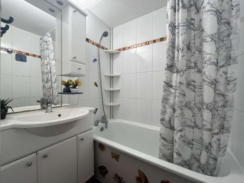 une salle de bain avec un lavabo et un rideau de douche dans l'établissement Maison 2 pièces cabine - Gruissan GN020-084, à Gruissan