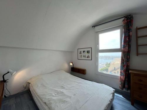 une chambre avec un lit blanc et une fenêtre dans l'établissement Appartement 3 pièces - Gruissan GN400-028, à Gruissan