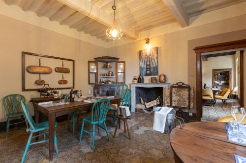 a dining room with a table and chairs and a fireplace at La Ripadoro Le Corti di Rivalto in Rivalto