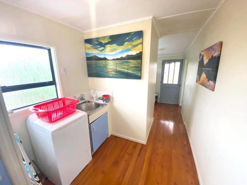 a small kitchen with a sink and a window at Pataua North By the Beach in Pataua