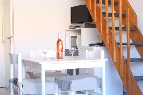 une salle à manger avec une table et deux verres de vin dans l'établissement Maison Studio Mezzanine - Gruissan Ayguades AY050-023, à Vires