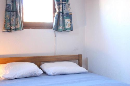 - un lit avec deux oreillers dans une chambre dotée d'une fenêtre dans l'établissement Maison Studio Mezzanine - Gruissan Ayguades AY050-023, à Vires