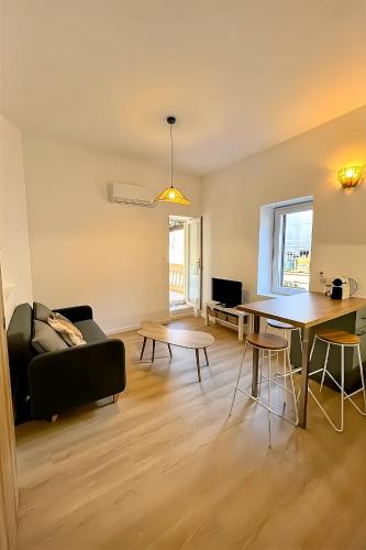 un salon avec une table et un canapé dans l'établissement 2 pièces proche Arènes - Terrasse & Clim, à Nîmes