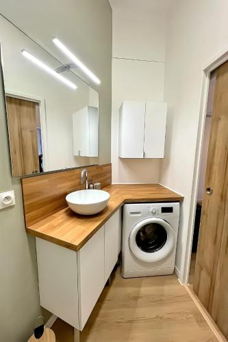 une salle de bain avec un lavabo et une machine à laver dans l'établissement 2 pièces proche Arènes - Terrasse & Clim, à Nîmes