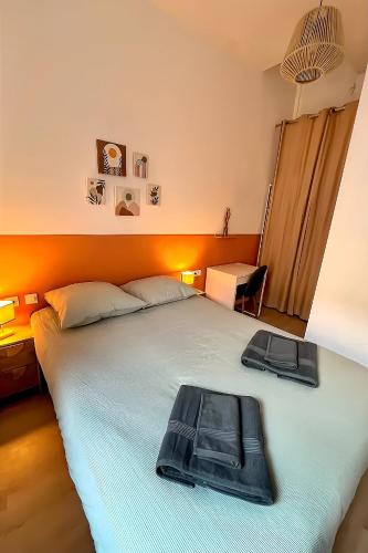 - une chambre avec un grand lit blanc et une tête de lit orange dans l'établissement 2 pièces proche Arènes - Terrasse & Clim, à Nîmes