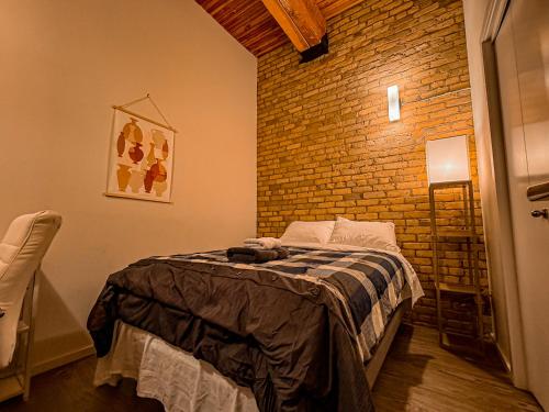 a bedroom with a bed with a brick wall at Heart of the City: Cozy 2-Bed Loft in Winnipeg