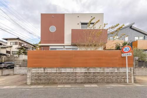 a building behind a fence in front of a house at ドリームホテル多々良 in Hakozaki