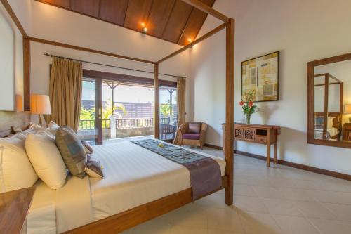 een slaapkamer met een bed, een bureau en een raam bij Villa Sedap Malam - Private 2 Bedroom Villa Near Seminyak Beach in Kuta