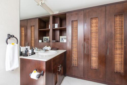 een badkamer met een wastafel en houten kasten bij Villa Sedap Malam - Private 2 Bedroom Villa Near Seminyak Beach in Kuta